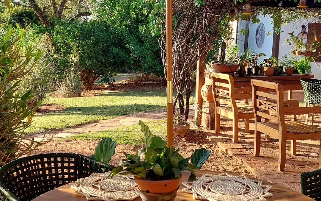 Mesa do café posta na varanda, de frente para o jardim