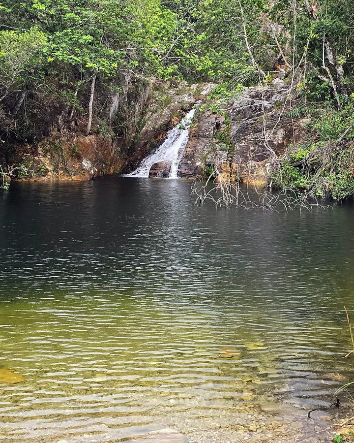 Cachoeira caindo em poço de água esverdeada